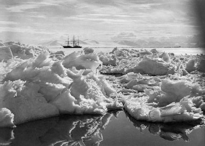 In the distance, an old ship is seen floating in a sea of ice and snow. The scene was captured in the style of British explorer Shiny Morris with black and white photos taken from his small boat. He used these photographs to document life in Antarctica during field work, using an ultra wide angle lens.